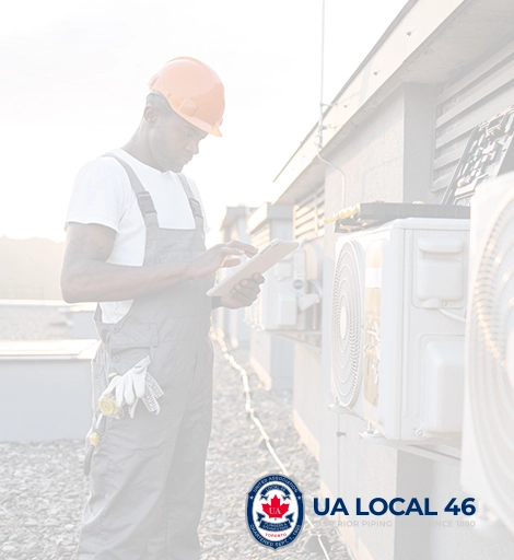A UA Local 46 worker inspecting a piping system at a worksite.